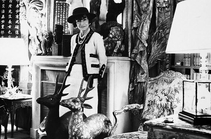 Black and white photo of Coco Chanel in a luxurious interior