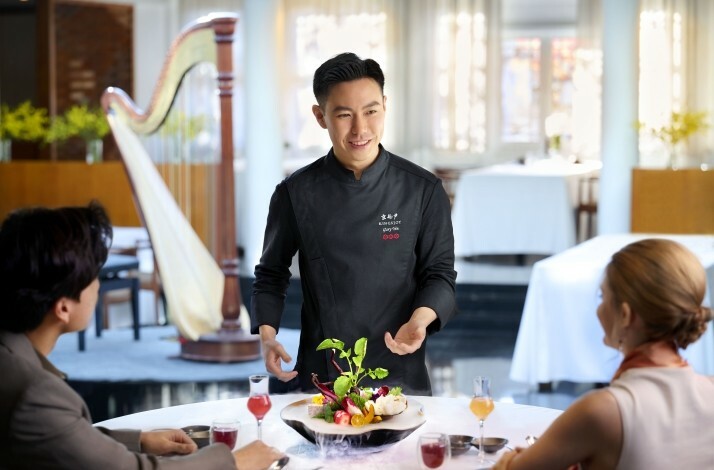 A couple enjoying a vegetarian lunch while being welcomed by the executive chef of King's Joy restaurant in Beijing, China.